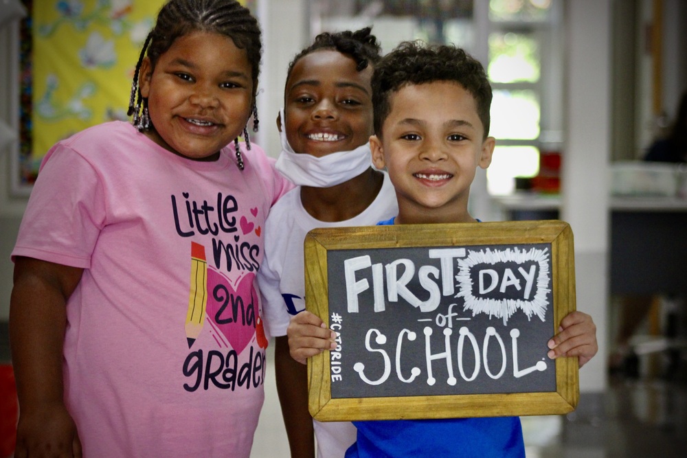 Children Holding First Day of School Sign