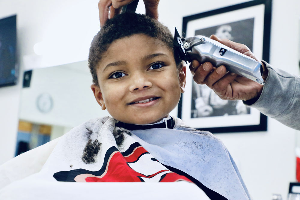 A SCSD student receives a free haircut from Champion City Cuts Barbershop